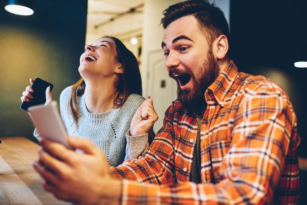 Couple cheering while looking at their phone